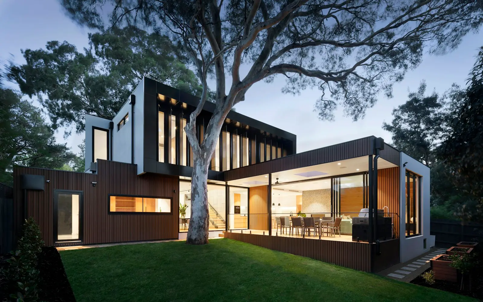 A modern rental home lit warmly at dusk